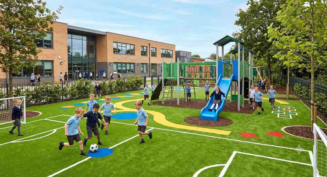 Children playing safely on vibrant artificial grass playground at St Mary's School in Birmingham with modern play equipment